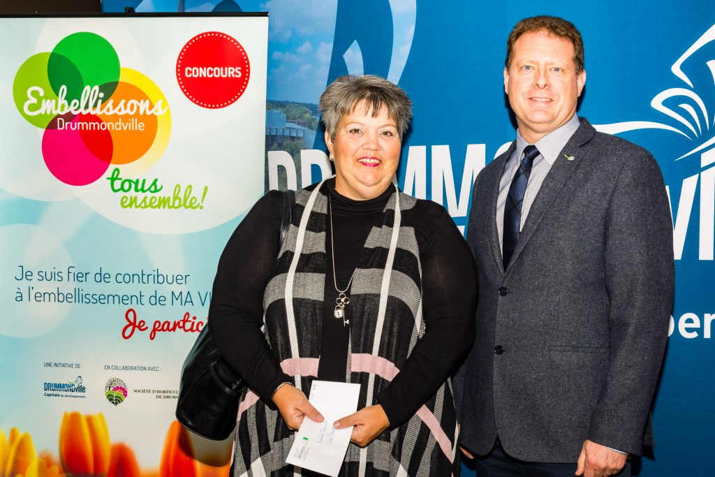 Catégorie Façade du district 12 (conseiller municipal Pierre Levasseur)
Guylaine Vigneault, accompagnée de François Pothier, directeur général adjoint gestion du territoite de la Ville de Drummondville. Elle reçoit un cadeau du Centre de jardin Alain Carrier.